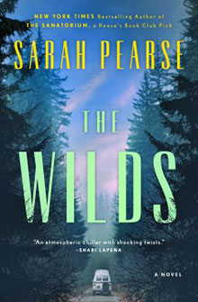Cover of the book "The Wilds" by Sarah Pearse, showing a car on a forest road under a dark, cloudy sky.