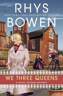 Book cover of "We Three Queens" by Rhys Bowen, featuring a woman in a coat outside a grand building.