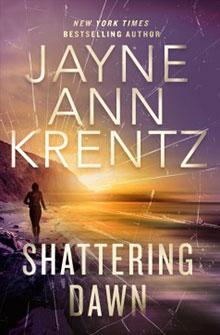 A person walks on a beach at sunset under the title "Shattering Dawn" by Jayne Ann Krentz.