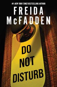 A yellow "Do Not Disturb" door hanger on a wooden door, with "Freida McFadden" written above it.