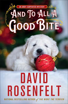 A puppy lies on a blanket, playfully biting a red ornament. The book title and author’s name are above and below.
