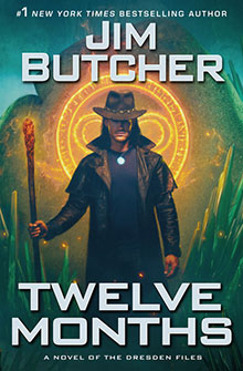 A man in a hat holds a staff with glowing runes behind him; text reads “Twelve Months, Jim Butcher.”.