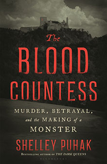 Book cover: "The Blood Countess" by Shelley Puhak, with a dark castle under cloudy skies in the background.