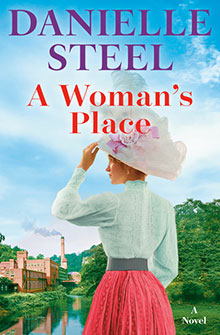 A woman in Victorian-era clothing stands by a river, with a factory and trees in the background. Book: A Woman’s Place.