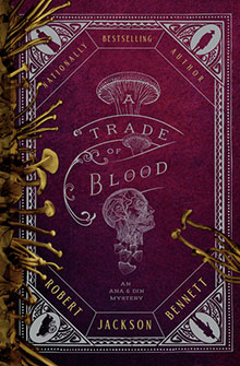 A red book cover with gold nails framing the edge, titled "A Trade of Blood" by Robert Jackson Bennett.