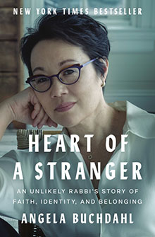 Book cover: "Heart of a Stranger" by Angela Buchdahl, featuring the author in glasses, seated and smiling gently.