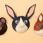Three animal masks on a beige background: a bear, a rabbit with long ears, and a fox.