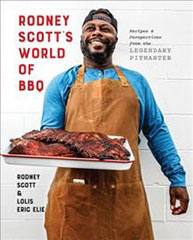 A person in an apron holding a tray of barbecue meat on the cover of "Rodney Scott's World of BBQ" book.