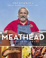 A man in a red shirt and apron holds a book titled "Meathead: The Science of Great Barbecue and Grilling.