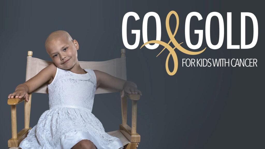 Smiling child in white dress sits on chair next to text: "Go Gold for Kids with Cancer" on dark background.