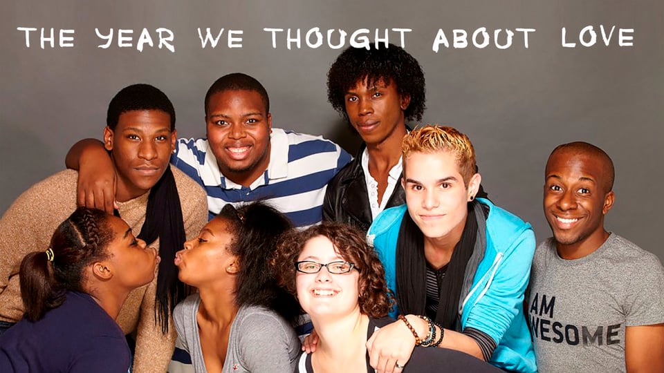 A diverse group of seven people smile and pose affectionately under the text "The Year We Thought About Love.