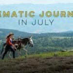 A woman leads a donkey through a green, hilly landscape with "Cinematic Journeys in July" text above.