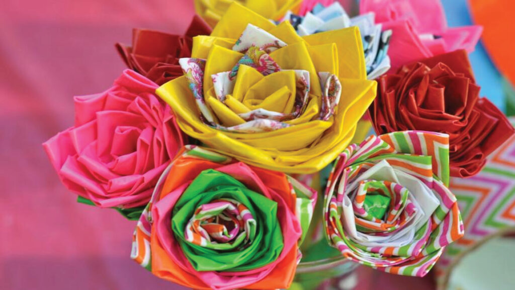 Colorful origami paper flowers arranged in a bouquet with various patterns and bright hues.