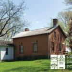 Historic brick and wood house surrounded by trees, with the Preservation Partners of the Fox Valley logo in the corner.