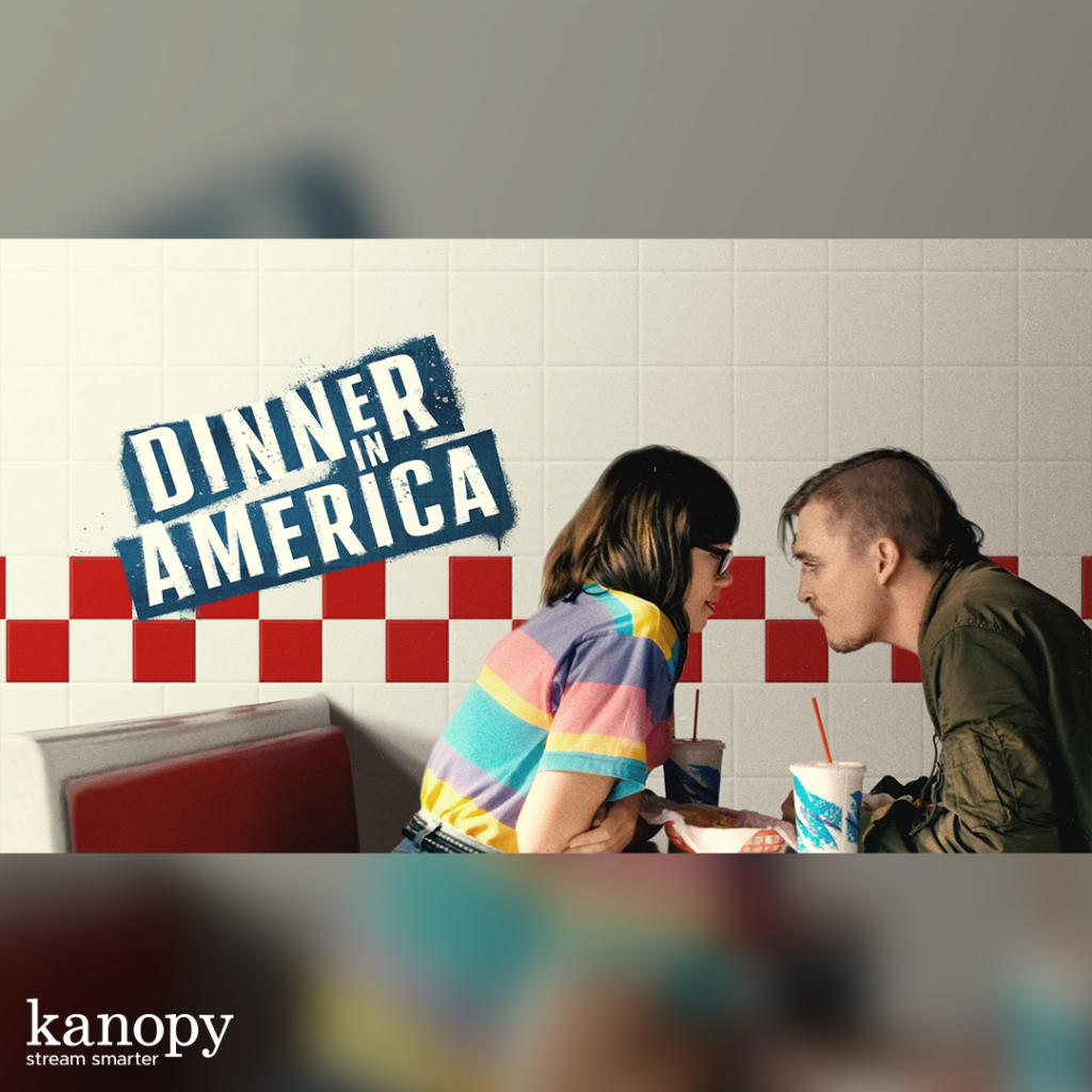 A man and woman lean close at a diner booth under the "Dinner in America" title with drinks on the table.