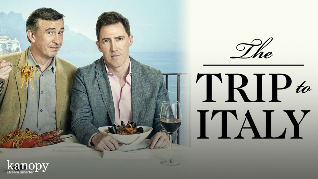 Two men sit at a table with pasta dishes and wine, with text reading "The Trip to Italy" beside them.