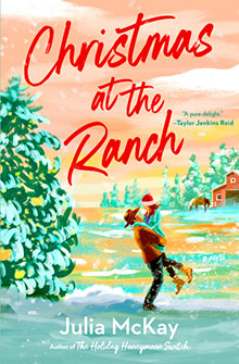 A couple embraces in snow near a barn; text reads "Christmas at the Ranch" by Julia McKay.
