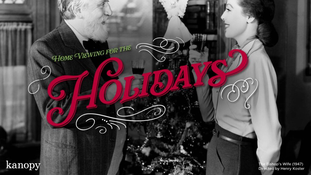 An older man and a woman smile and toast drinks by a Christmas tree, with "Holidays" in festive text.