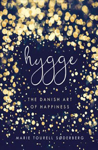 Book cover with title "Hygge: The Danish Art of Happiness" by Marie Tourell Soderberg. Background of golden bokeh lights.