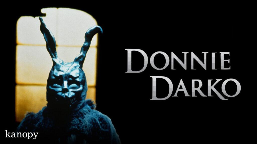 A person in a dark bunny costume stands by a window, with "Donnie Darko" written beside them.