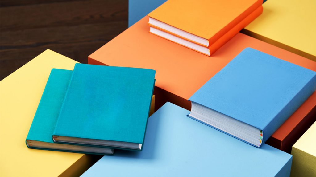 Various colorful books arranged on colorful surfaces in a visually appealing layout.