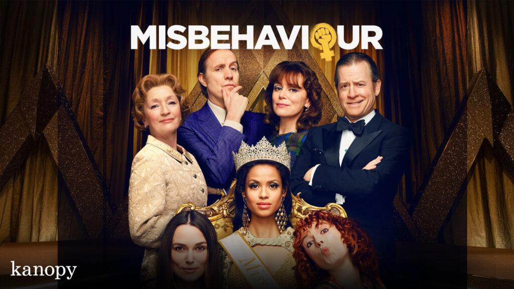 Seven well-dressed people pose under the "MISBEHAVIOUR" title, with a woman wearing a pageant crown in front.