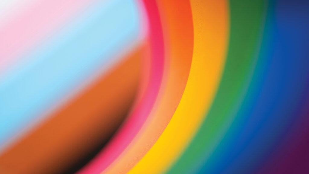 Close-up of colorful curved stripes, including pink, yellow, orange, green, and blue, creating an abstract pattern.