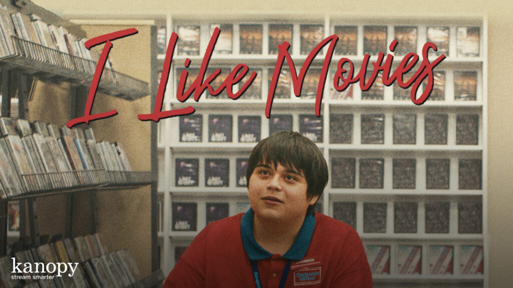 A young man in a red polo sits in a video store under bold text reading “I Like Movies.”.