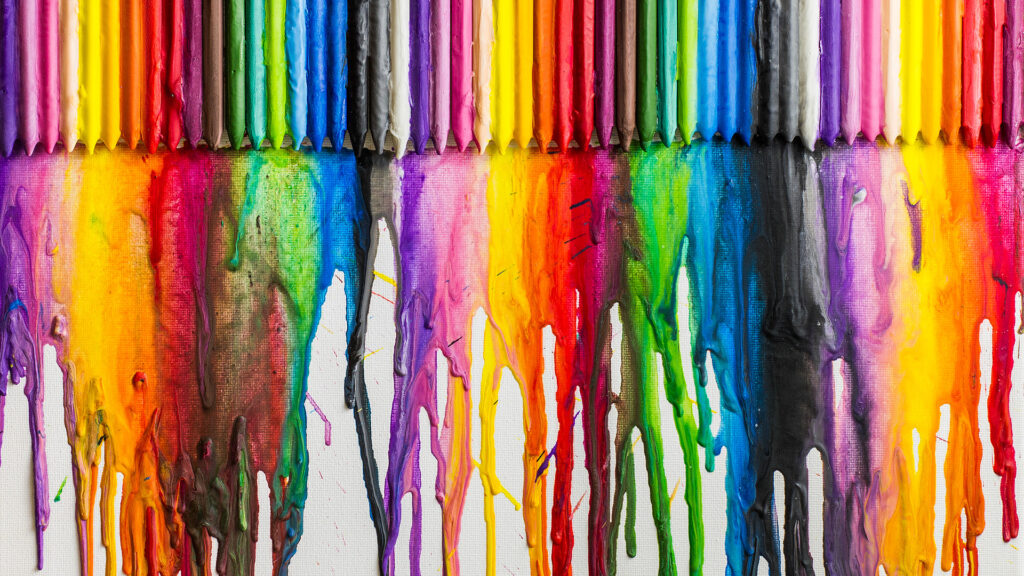 Colorful crayons melting and dripping wax down a white canvas, creating a vibrant rainbow effect.