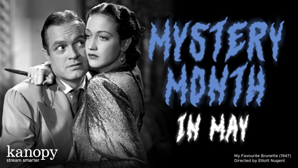 A worried man and woman embrace with "Mystery Month in May" written in jagged blue letters beside them.