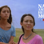 Three women stand together outside under a blue sky with text saying "Native American Heritage Month.
