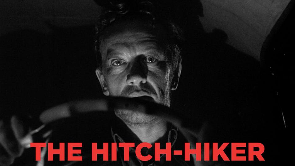 A man illuminated from below holds a steering wheel. The text "The Hitch-Hiker" is in bold red letters at the bottom.