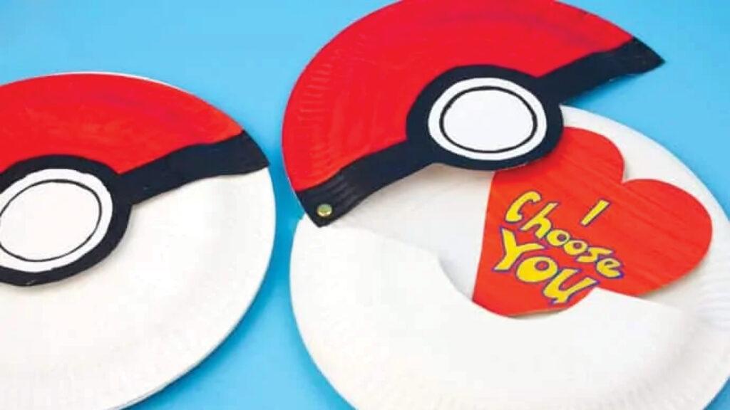 Two paper plate Poké Balls, one opened to reveal a red heart with the text "I Choose You.