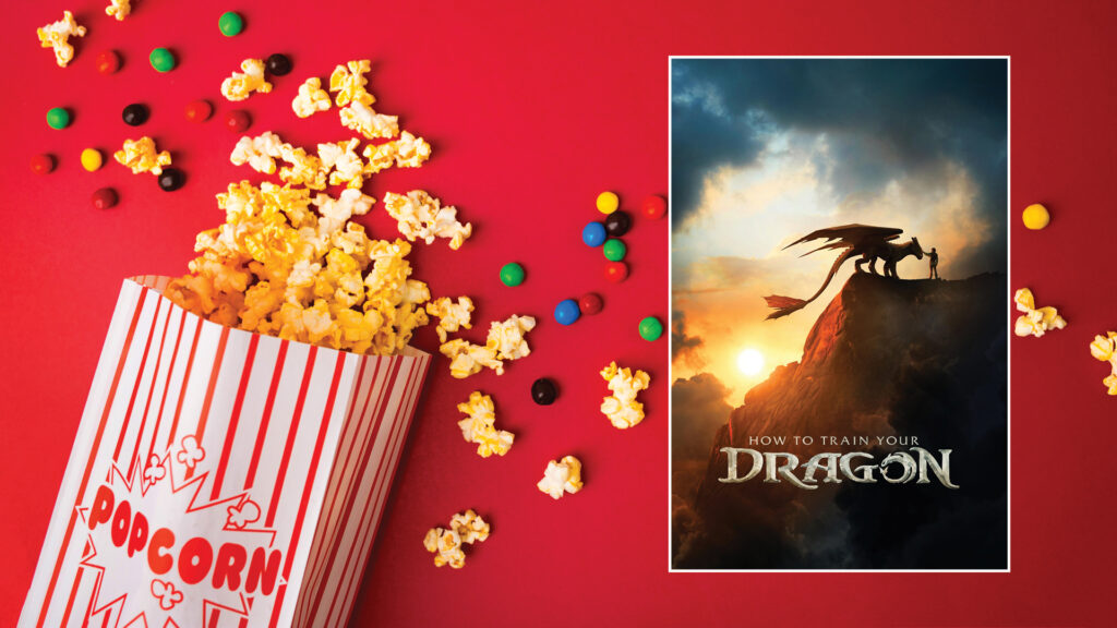 A popcorn box and candy spill next to a "How to Train Your Dragon" movie poster on a red background.