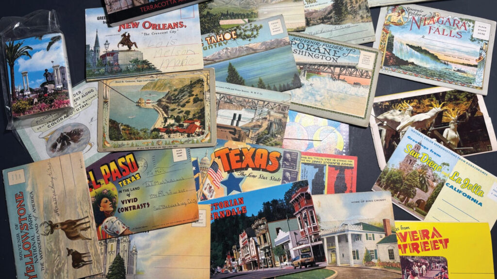 Assorted vintage postcards from various U.S. destinations spread out on a flat surface.