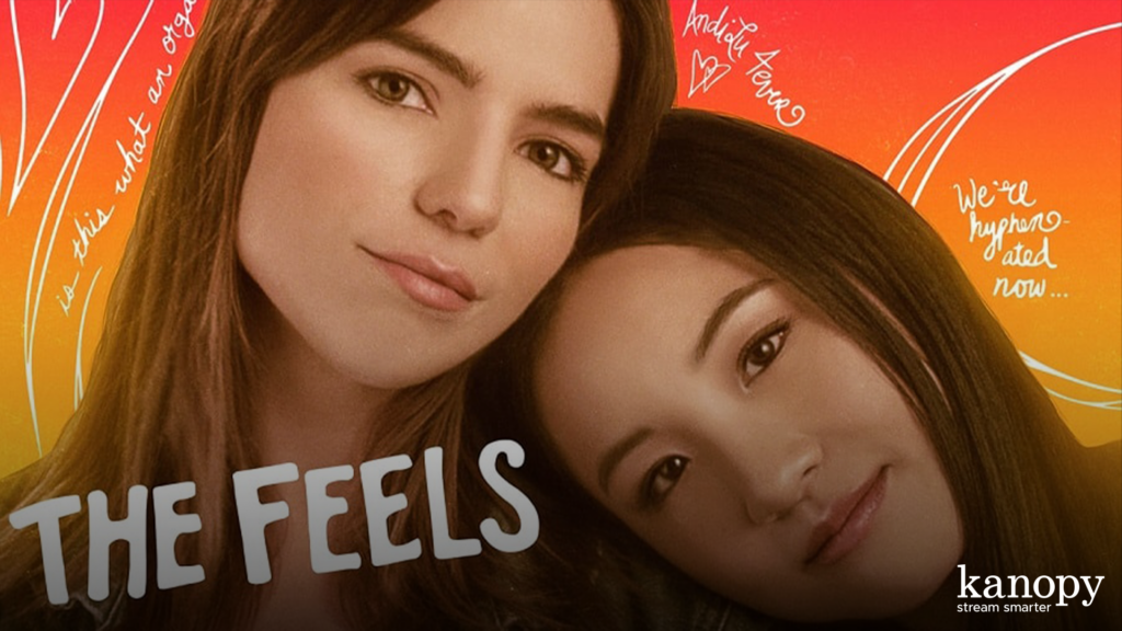 Two women lean close together, smiling, with "THE FEELS" written in bold letters and a colorful background.
