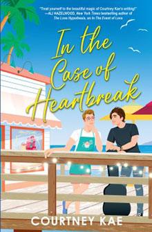 Two people stand by a boardwalk railing with storefronts in the background, under the title "In the Case of Heartbreak.