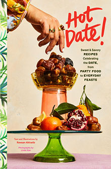 A hand reaches for dates in a glass bowl; assorted fruit sits below; text reads "Hot Date!" on the right.