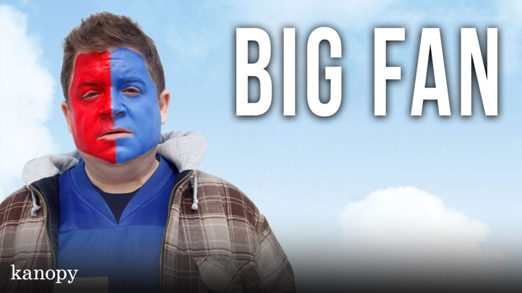 A person with half-red, half-blue face paint stands under "BIG FAN" text, wearing a plaid jacket and blue shirt.