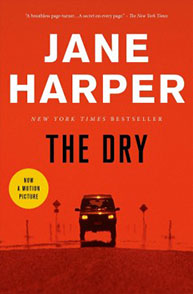 Cover of the book "The Dry" by Jane Harper, featuring a car driving on a desert road under an orange sky.