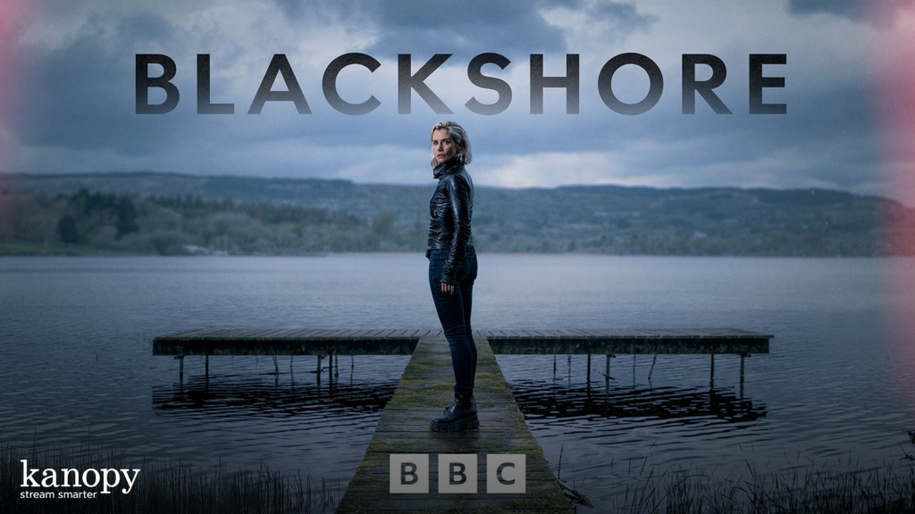 A woman stands on a dock over a lake with “BLACKSHORE” in bold letters above and BBC and Kanopy logos below.