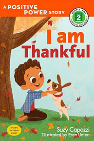 A boy with a dog under a tree in autumn on the book cover "I Am Thankful" by Suzy Capozzi.