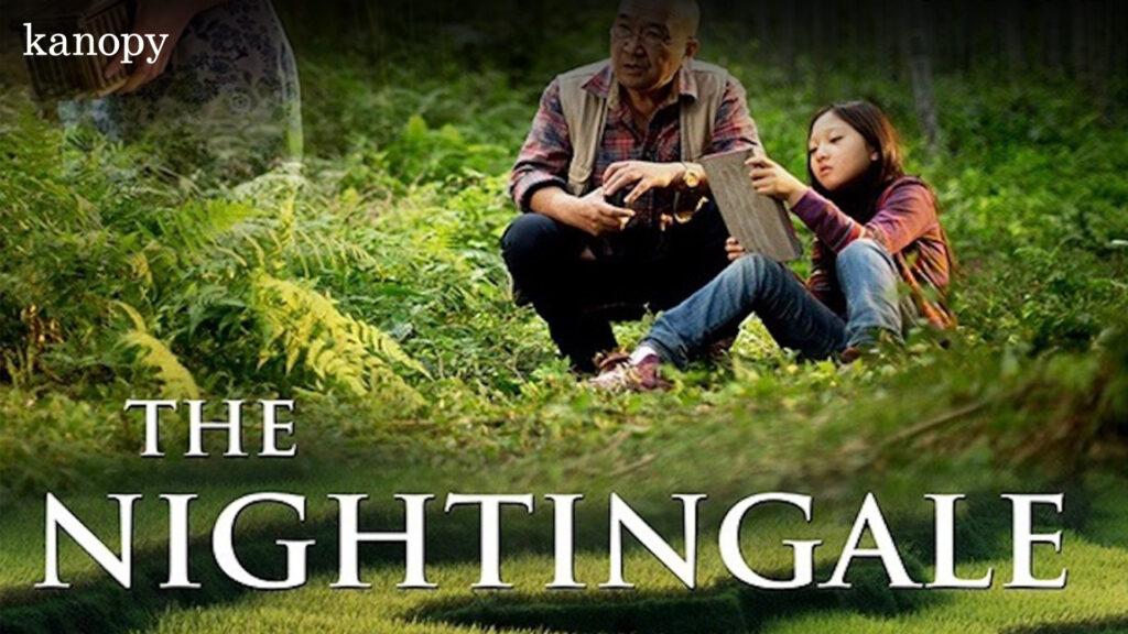 An older man and a young girl sit together in a lush green field; text reads "The Nightingale.