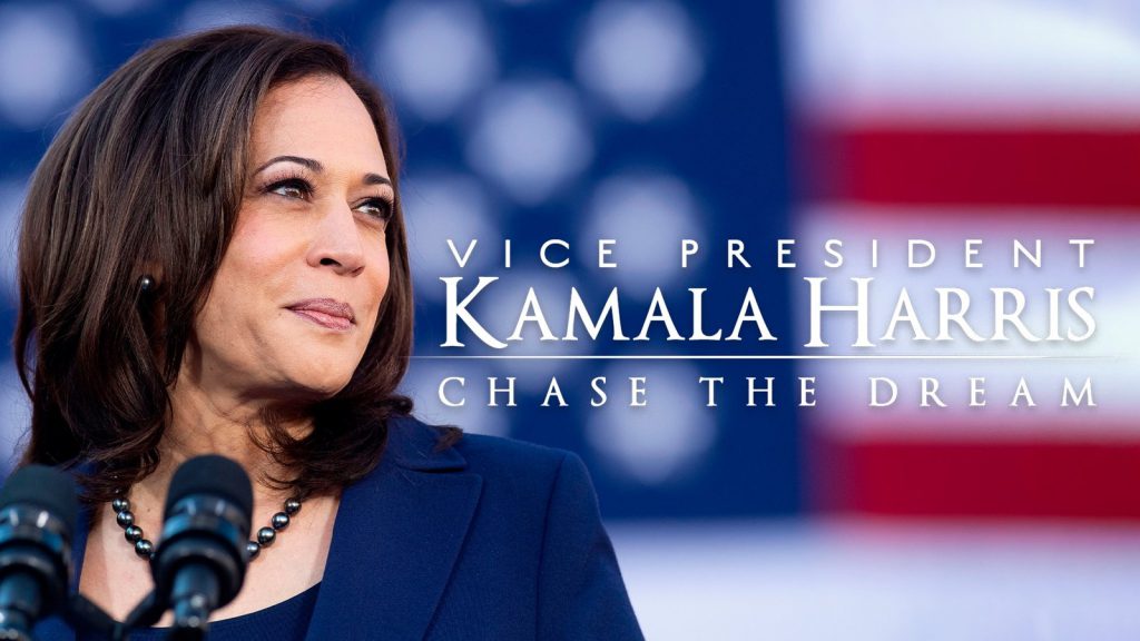 Kamala Harris stands in front of a blurred American flag with text "Vice President Kamala Harris: Chase the Dream.