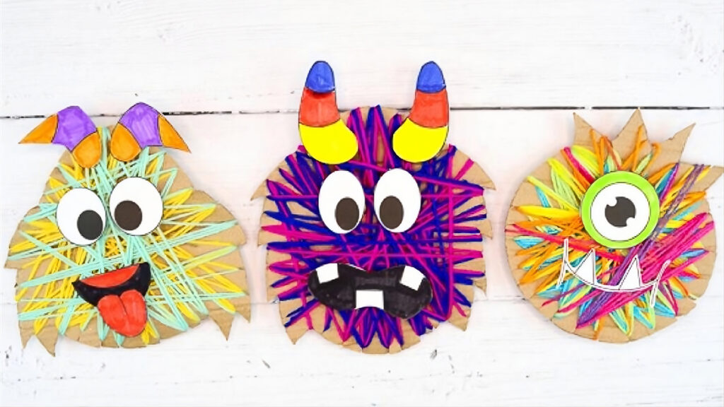 Three colorful yarn-wrapped monster faces with googly eyes and silly expressions on cardboard backgrounds.