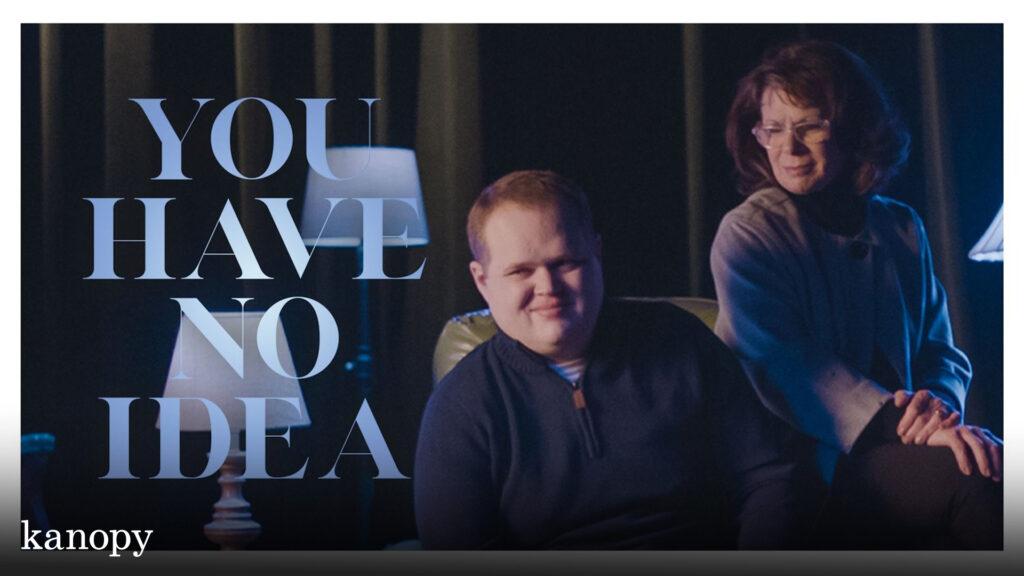 A smiling man sits while a woman stands beside him; text reads, "YOU HAVE NO IDEA." Kanopy logo at bottom left.